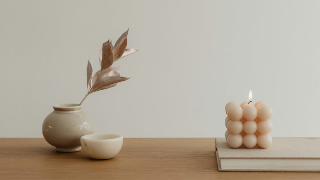candle-and-a-vase-on-a-table-T6_xGWpXnHc