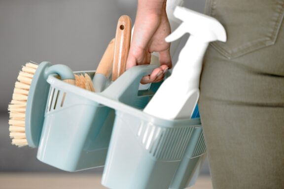 Cleaning tools, clean service and brush with hands holding basket with sponge and hygiene products. Mockup for ecofriendly detergent, domestic chores and cleaning service for janitor or maid working