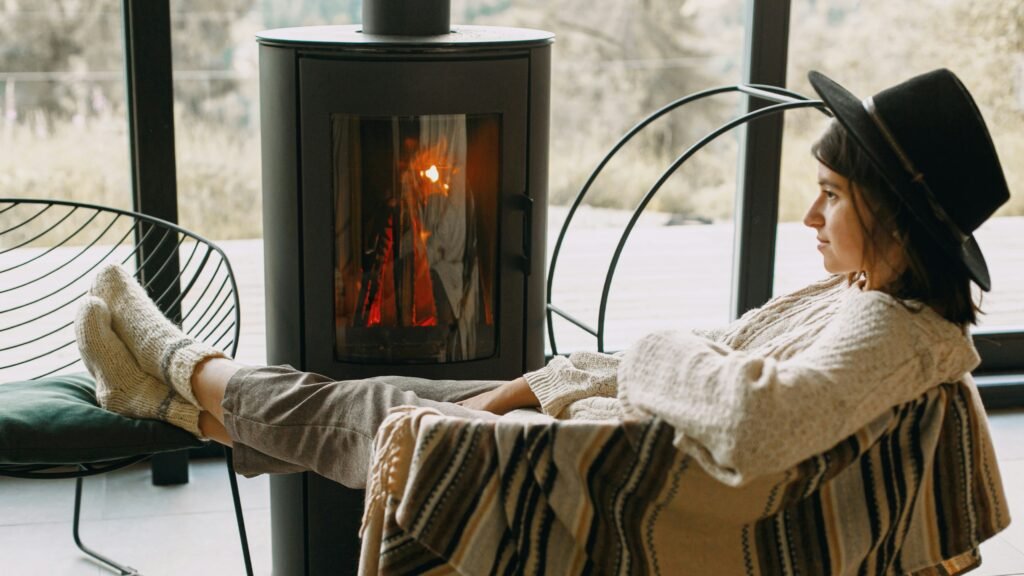 Woman with her feet on a chair next to a window and fireplace
