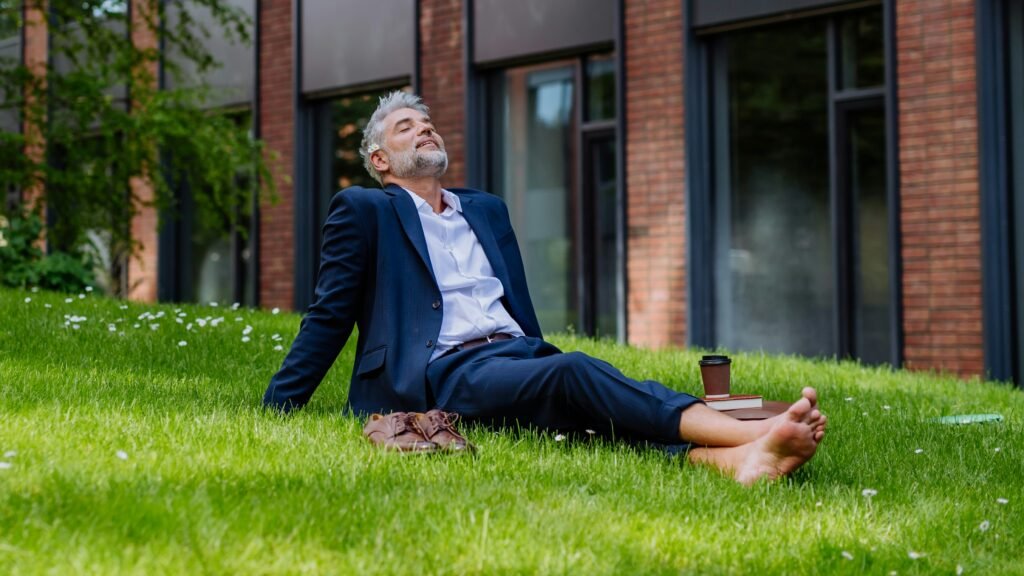 mature-businessman-resting-and-sitting-barefoot-in-park-feeling-free-escaping-from-work-work-life-balance-concept-kNyFMUzh9JQ