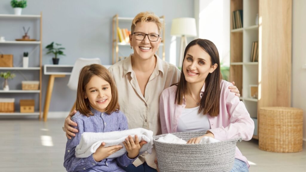 Happy family, three generations embracing beloved child, mom and grandma holding laundry basket after washing clothing