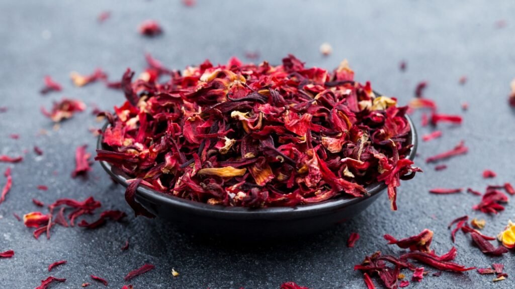 Hibiscus tea in black bowl. Slate background. Copy space.