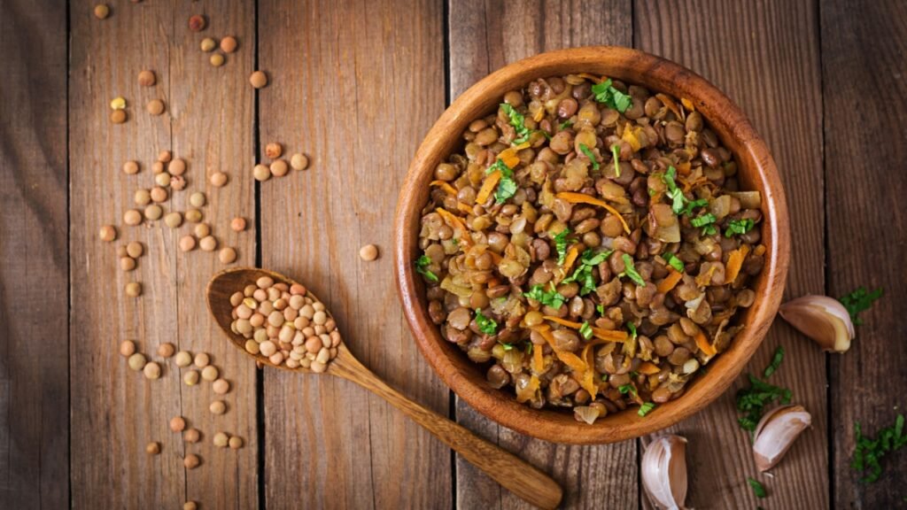 Lentil with carrot and onion in a wooden bowl. Healthy lifestyle. Diet menu. Top view. Flat lay