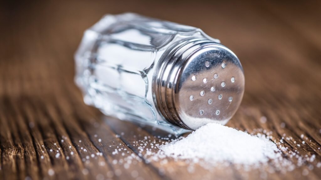 Old wooden table with a Salt Shaker (close-up shot; selective focus)