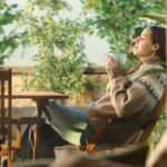 Profile of a woman in a house terrace drinking coffee and breathing