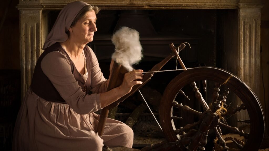 Renaissance Old Master portrait of a woman with antique spinning wheel in front of a fireplace