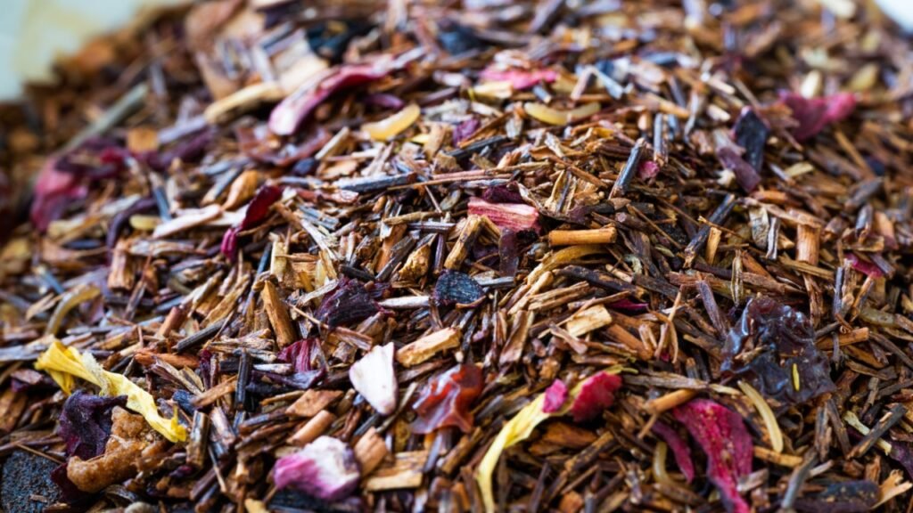 Winter Berry Dried Rooibos Tea Pieces with Dry Strawberry, Hibiscus, Flavoring, Cinnamon, Cloves, Rosehip, Apple, Calendula, Vanilla bits. Close Up Macro View.