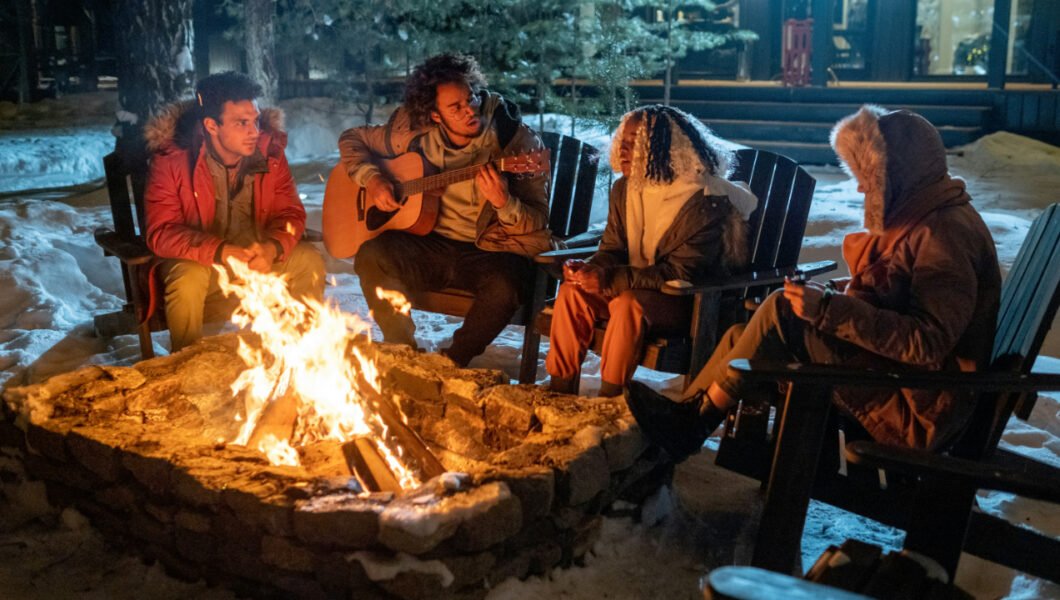 friends playing music around a campfire