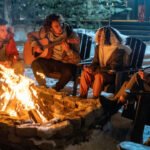 friends playing music around a campfire