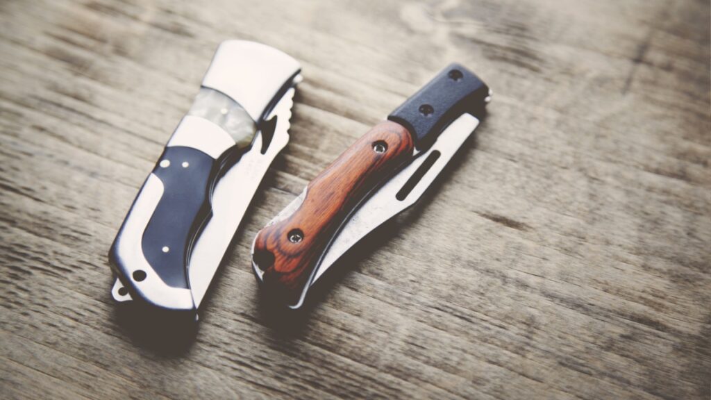 two pocket knife on wooden table