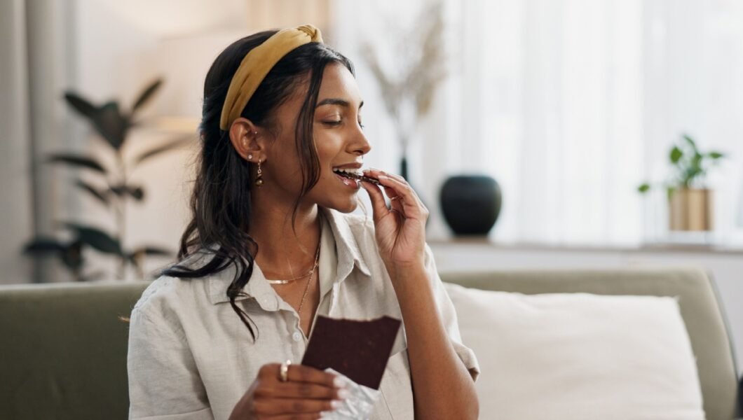 woman eating a piece of chocolate