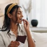 woman eating a piece of chocolate